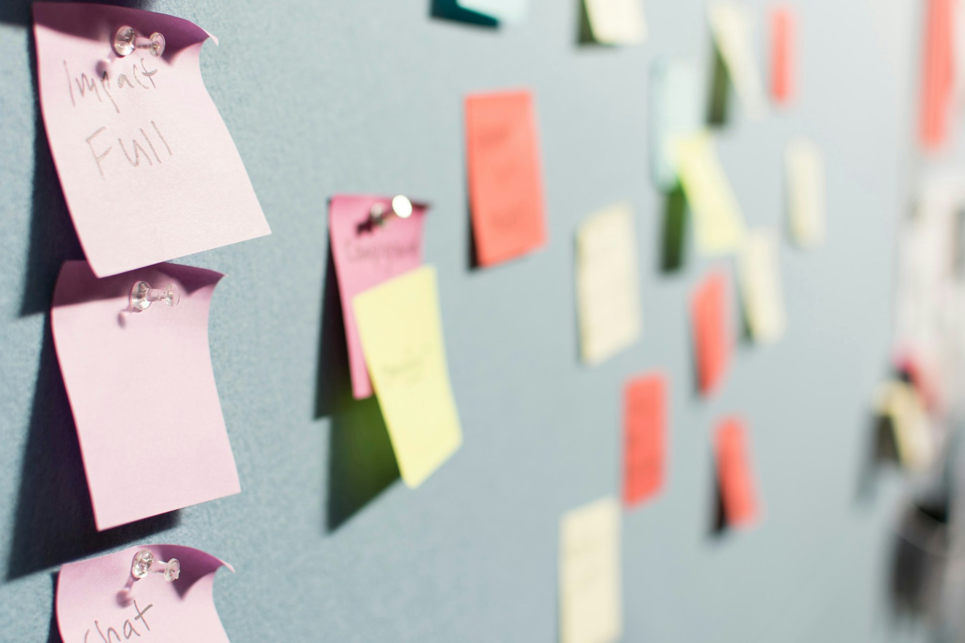 Post-its colorés épinglés sur un tableau de planification, par Patrick Perkins sur Unsplash