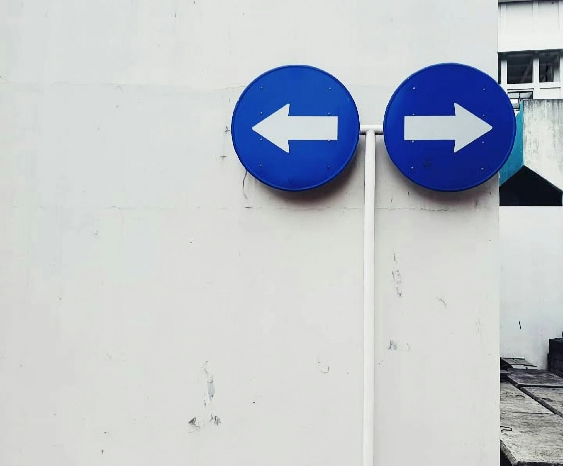 Deux panneaux directionnels bleus pointant dans des directions opposees symbolisant le choix entre Fibonacci et T-Shirt Sizing