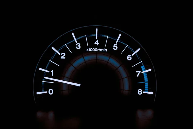 Illuminated car tachometer with white numbers and a blue scale, a metaphor for the sprint velocity of a Scrum team