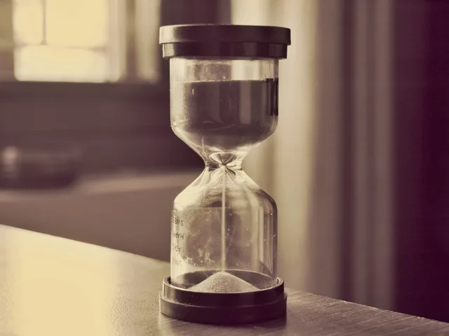 Sablier en verre avec du sable qui s'ecoule symbolisant la mesure du temps en jours-homme